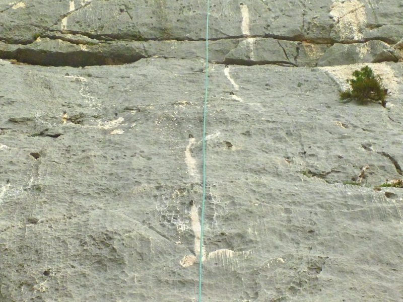 White streaks on the rock generated over time by permanent anchors, photo Marco Marrosu